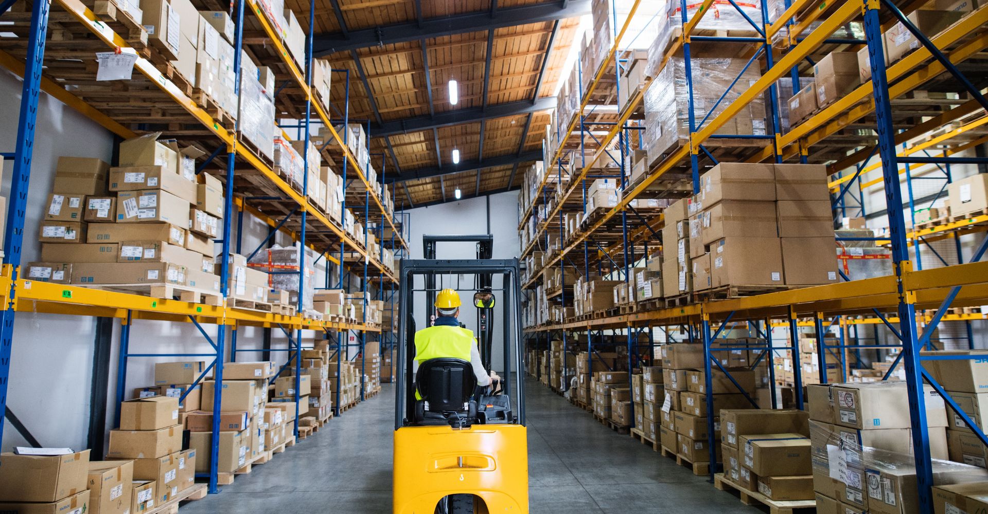 A factory worker using a lift in a freshly coated warehouse