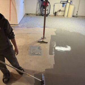 Working on the epoxy distribution for a basement floor