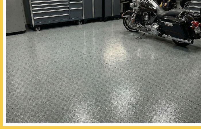 A clean, organized garage workshop in Kennedale with a durable polyurea floor, tool cabinets, and a motorcycle.