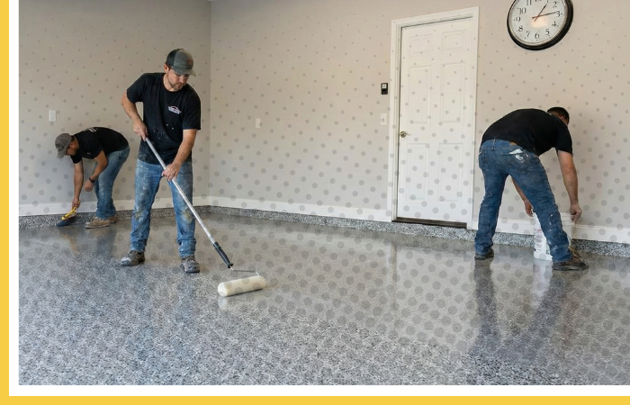 Professional concrete flooring team installing a new polyurea garage floor with a flake finish.
