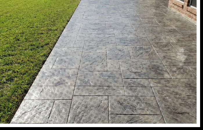 A modern stamped concrete patio with a slate texture in a Kennedale backyard.