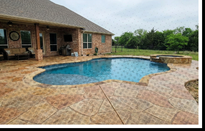 A beautiful pool deck and patio with a decorative concrete overlay resembling natural stone in a Parker County backyard.