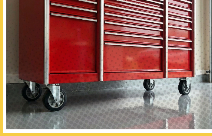 A large red tool chest sits on a glossy polyurea garage floor, showcasing the floor's durability and resistance to heavy loads.