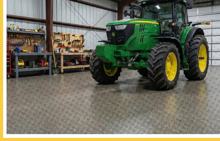 A large green tractor parked inside a metal barn with a heavy-duty polyurea floor coating.