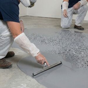 Two professionals from BAM Coatings applying a multi-layered concrete overlay system, debunking the myth that it is just paint.