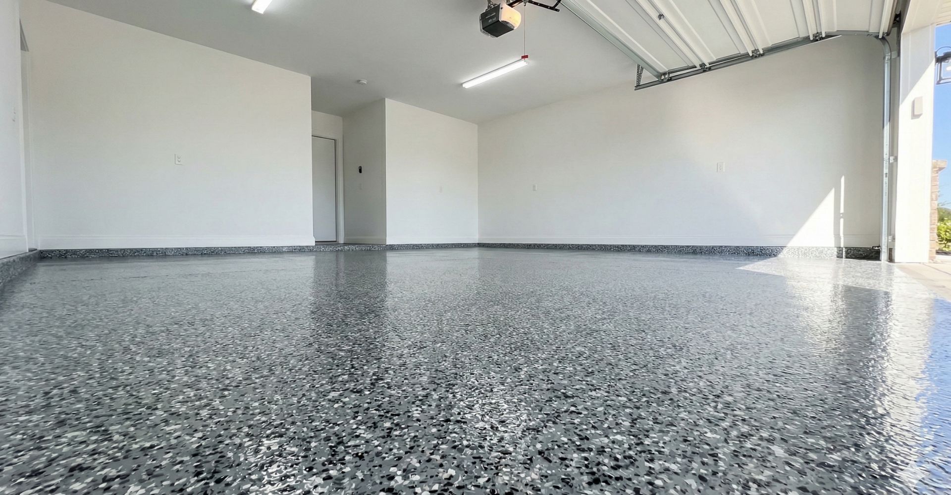 Modern garage with glossy grey polyurea concrete floor coating by BAM Coatings.