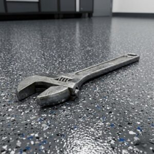 A heavy wrench resting on a chip-resistant polyurea floor coating, illustrating extreme durability.