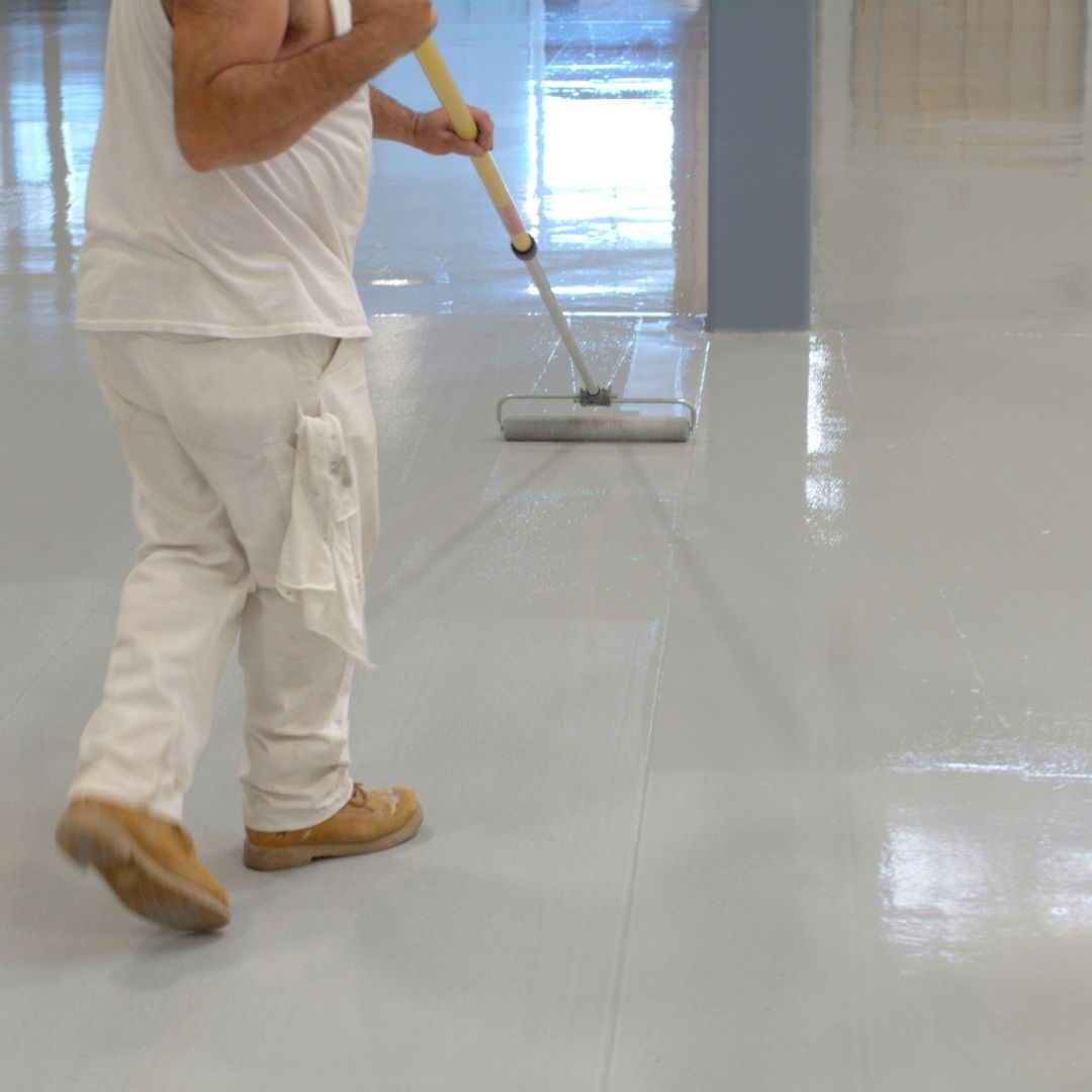 a person cleaning a coated floor