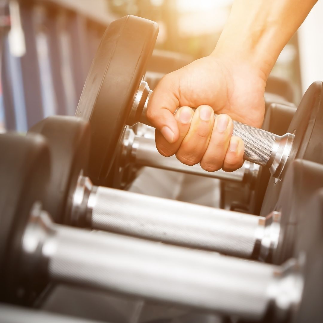 a person picking up a dumbbell